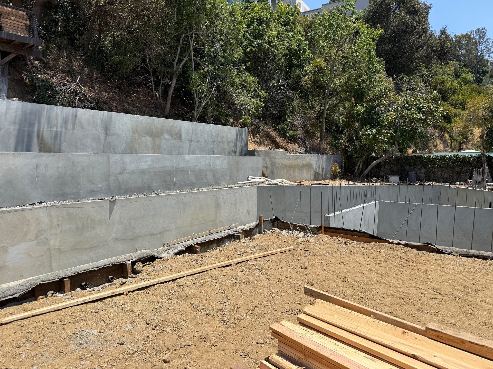Board formed concrete retaining wall stabilizing a hillside property